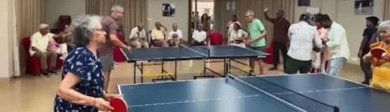 A group of elderly residents enjoying activities together in a senior citizen home environment.