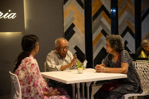 Residents engaging in adda and cultural activities at Aumorto, showcasing the vibrant community life unlike a traditional old age home