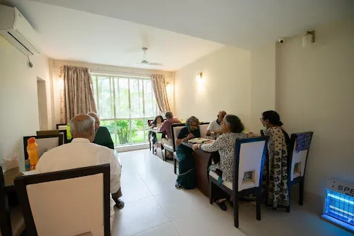 Seniors enjoying nutritious meals together in a communal dining hall, showcasing the social dining experience missing in traditional old age homes.