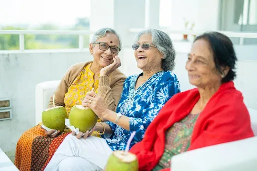 Senior residents enjoying adda sessions and shared meals at Aumorto retirement living community.